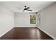 Bedroom with dark hardwood floors, ceiling fan, and a view of the outside through the window at 5104 E Longboat Blvd, Tampa, FL 33615