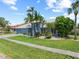 Charming home with a well-manicured lawn, lush landscaping, and beautiful palm trees at 5104 E Longboat Blvd, Tampa, FL 33615