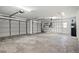 A large garage with two garage doors, a door to the outside, water heater, and shelving at 5104 E Longboat Blvd, Tampa, FL 33615