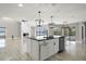 Open concept kitchen island with black countertop, sink, dishwasher, pendant lighting, and view of living area at 5104 E Longboat Blvd, Tampa, FL 33615