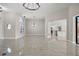 Open living space with elegant tile flooring, modern chandeliers and an arched window feature at 5104 E Longboat Blvd, Tampa, FL 33615