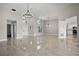 Open living area with tile floors, pendant lighting, and entryway featuring arched windows at 5104 E Longboat Blvd, Tampa, FL 33615