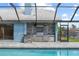 Screened in lanai with stone outdoor kitchen including grill, backsplash, lighting, and storage at 5104 E Longboat Blvd, Tampa, FL 33615