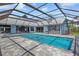 A view of the screened pool area with heated pool and spa; outdoor kitchen area includes a grill at 5104 E Longboat Blvd, Tampa, FL 33615