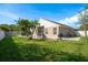 Spacious backyard features an in-ground pool, patio, grill, lush lawn, and mature palm trees at 632 Lake Cypress Cir, Oldsmar, FL 34677