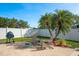 View of a charming backyard featuring a grill, chairs, and lush tropical landscaping at 632 Lake Cypress Cir, Oldsmar, FL 34677