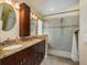 Bathroom with a double sink vanity with granite countertops, a framed mirror, and glass door shower at 632 Lake Cypress Cir, Oldsmar, FL 34677