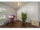 Clean bedroom with hardwood floors, a window overlooking the lawn, and a cozy cat tree for furry residents at 632 Lake Cypress Cir, Oldsmar, FL 34677