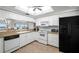 Well-lit kitchen featuring white cabinetry, granite counters, and modern black appliances at 6475 Shoreline Dr # 5403, St Petersburg, FL 33708