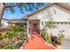 Inviting front entrance with a red door, charming landscaping, and a well-maintained walkway at 7201 15Th Ne Ct, St Petersburg, FL 33702