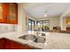 Bright kitchen with granite countertops, stainless steel sink, and view of the backyard pool at 7201 15Th Ne Ct, St Petersburg, FL 33702