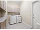 Clean laundry room with modern washer and dryer, overhead cabinets, and tiled floor at 7201 15Th Ne Ct, St Petersburg, FL 33702