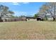 Backyard with a privacy fence, lawn, and mature trees at 827 Louise St, Brandon, FL 33511