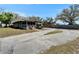 One-story home with a screened porch, a spacious driveway, and mature trees at 827 Louise St, Brandon, FL 33511