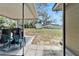 Covered patio with patio chairs overlooking the spacious backyard and mature trees at 827 Louise St, Brandon, FL 33511