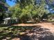 Angle view of home surrounded by mature trees and lush green grass at 832 S Parsons Ave, Brandon, FL 33511