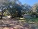 View of the home and the storage units on the property, surrounded by trees at 832 S Parsons Ave, Brandon, FL 33511