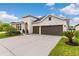 Spacious driveway leading to a well-maintained home with a two-car garage and lush green lawn under a blue sky at 1106 Tracey Ann Loop, Seffner, FL 33584