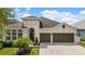 Charming home with well-manicured lawn and landscaping, showcasing a two-car garage and inviting architectural details at 1106 Tracey Ann Loop, Seffner, FL 33584