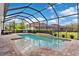 Inviting screened-in pool area with a sun shelf, surrounded by lush landscaping at 1106 Tracey Ann Loop, Seffner, FL 33584