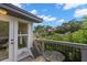 Balcony with a small table and chair overlooking lush greenery and a bright blue sky at 115 21St Ne Ave, St Petersburg, FL 33704
