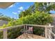 Balcony with a small table and chair overlooking lush greenery and a bright blue sky at 115 21St Ne Ave, St Petersburg, FL 33704