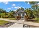 Charming cottage-style home with manicured front yard, lush tropical landscaping, and a concrete walkway at 115 21St Ne Ave, St Petersburg, FL 33704
