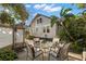 Charming backyard patio with dining set, lush landscaping, and a view of the home's exterior at 115 21St Ne Ave, St Petersburg, FL 33704