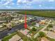 Aerial shot with arrow pointing to a canal-front home featuring a private boat dock, lush landscaping, and direct access to the gulf at 121 Colonial Sw St, Port Charlotte, FL 33952