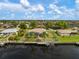 An aerial view of a waterfront home featuring a private boat dock, screened lanai, and well-maintained landscaping at 121 Colonial Sw St, Port Charlotte, FL 33952