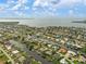 Expansive aerial view of waterfront homes with canals and boat docks leading to the open bay at 121 Colonial Sw St, Port Charlotte, FL 33952