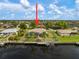 An aerial view of a waterfront home featuring a private boat dock, screened lanai, and well-maintained landscaping at 121 Colonial Sw St, Port Charlotte, FL 33952