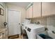 Laundry room equipped with a washer, dryer, storage cabinets, and a utility sink at 121 Colonial Sw St, Port Charlotte, FL 33952