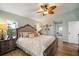 Spacious main bedroom with wood floors, a ceiling fan, and private access to the main bathroom at 121 Colonial Sw St, Port Charlotte, FL 33952