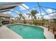 Sparkling screened-in pool surrounded by lush greenery and serene waterfront views at 121 Colonial Sw St, Port Charlotte, FL 33952