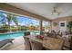 Inviting outdoor patio with wicker furniture overlooking a sparkling pool and lush landscaping at 121 Colonial Sw St, Port Charlotte, FL 33952