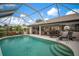 Inviting pool area with covered patio, lounge chairs, and a view of the home's exterior at 121 Colonial Sw St, Port Charlotte, FL 33952