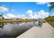 Waterfront view from a private dock, showcasing the serene canal waters, surrounding homes, and clear blue sky at 121 Colonial Sw St, Port Charlotte, FL 33952