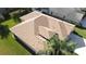 Aerial view of a well-maintained roof and lush green lawn, surrounded by mature palm trees and landscaping at 1430 Beaconsfield Dr, Wesley Chapel, FL 33543