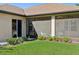 View of the patio from the yard featuring a screened in area, lush grass, and landscaping at 1430 Beaconsfield Dr, Wesley Chapel, FL 33543