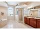 Bright bathroom features a glass shower, garden tub, and vanity with granite countertop at 1430 Beaconsfield Dr, Wesley Chapel, FL 33543
