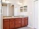 Bathroom with double sinks, wood cabinets, large mirror and white trim throughout at 1430 Beaconsfield Dr, Wesley Chapel, FL 33543