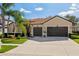 Attractive home featuring a two-car garage, appealing lawn, and lovely landscaping under a blue sky at 1430 Beaconsfield Dr, Wesley Chapel, FL 33543