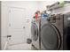 Functional laundry room features modern machines and shelving, with convenient access to a door at 1430 Beaconsfield Dr, Wesley Chapel, FL 33543