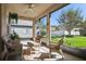 Relaxing screened-in patio with comfortable wicker furniture and view of the landscaped backyard at 1430 Beaconsfield Dr, Wesley Chapel, FL 33543