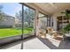 The screened patio, featuring wicker furniture, allows seamless transition to outdoors and backyard at 1430 Beaconsfield Dr, Wesley Chapel, FL 33543