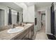 Bathroom featuring double sinks with granite countertops, and a view into the walk-in closet at 1547 Golden Glow Dr, Ruskin, FL 33570
