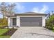 Charming single-story home with a gray garage door and a beautifully paved driveway at 1721 Shevlin St, North Port, FL 34286