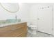Bathroom featuring modern glass bowl sink and cabinet, toilet, and white door at 18236 Paradise Point Dr, Tampa, FL 33647