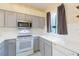 Well-lit kitchen features white subway tile backsplash, stainless steel microwave, and window views at 18236 Paradise Point Dr, Tampa, FL 33647